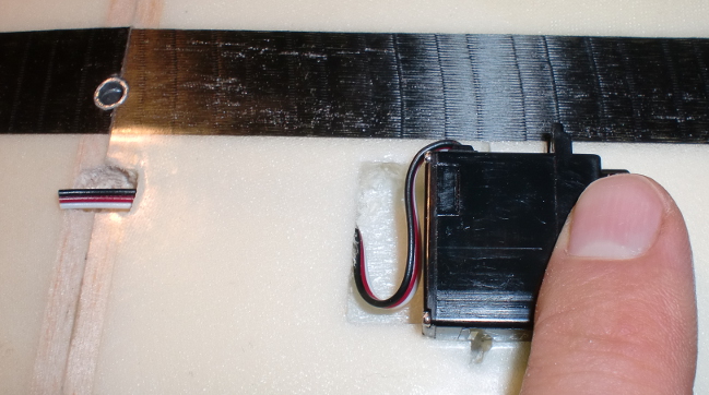 On insère le servo en faisant prendre la bonne position au fils